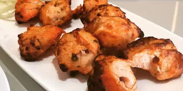 Tandoori chicken tikka served on a platter at Lovely Sweets Calgary northeast