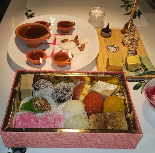 Diwali sweet box with lit diyas at Lovely Sweets Saddletowne Calgary